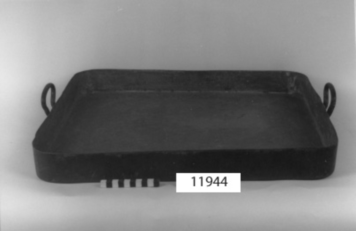 Stekplåt av koppar, förtent. Rektangulär med uppvikta kanter och avrundade hörn samt två handtag. Märkning: äldre kronstämpel  Fylgia Off. Kök.