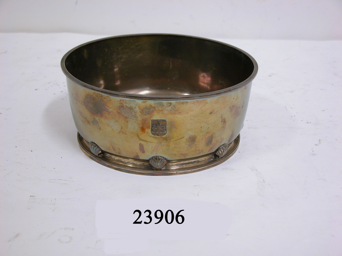 Rund silverskål med lätt profilerad överkant. Nertill insvängd med vågdekorerad fris och plastiska musselskal över en platt och låg fot.
På undersidan stämplat: Borgila, tre kronor, S. Stockholmsstadsvapen R8 Sterling. Samt ingraverat: H.M. Jagare Hälsingborg från AB De Lavals ångturbin.