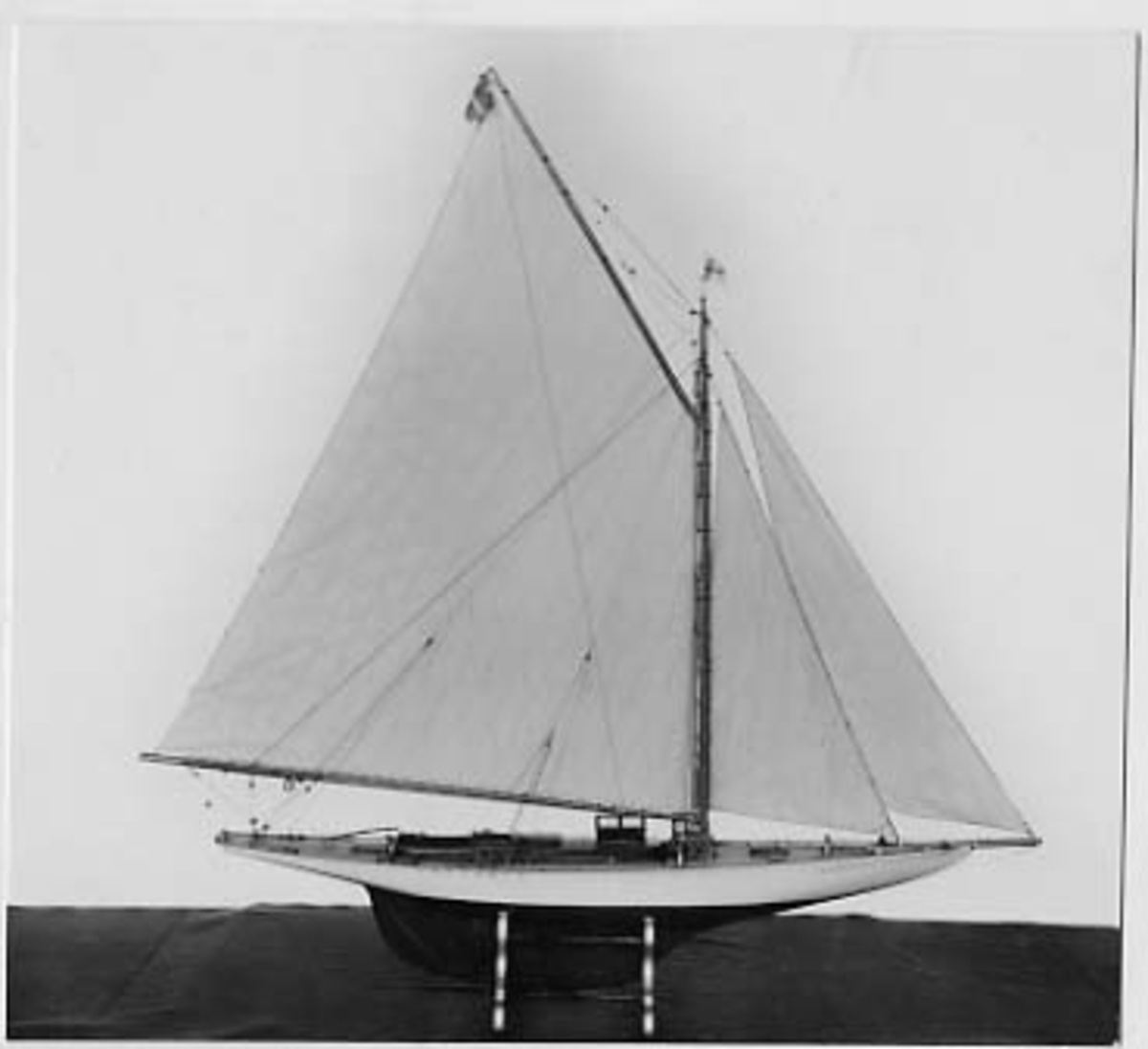 Segelkutter, skärgårdskryssaren ALCA. Fullständigt inredd med kajuta och sittrum. Modell byggd i ett trä. Riggad. Mast i en längd med gaffelsegel, fock och klyvare. Flagga och igenkänningsstandert. Vitmålad, röd botten. Fernissat däck och inredning. Stativ fernissat och förgyllt.
Alca var  45, 2 fot lång och 8,9 fot bred
