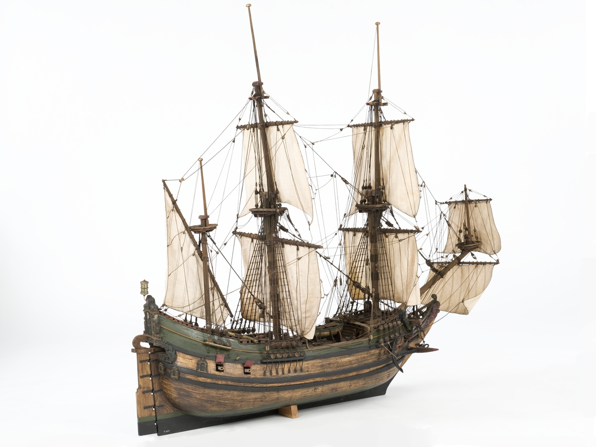 Flöjtskeppsmodell. Riggat med stående och löpande gods, segel av bomull. Bogspröt m. 2 blindor. Fock- o stormast med märs- och undersegel. Latinsegel på mesanmasten. Galjon m. lejon. 2 bogankare, båt på skrå midskeppsöver storluckan. På halvdäck 2 metallkanoner, 4 bogkanoner, samt 4 kanoner på låringen. 1 campagnelykta. Mörkbetsat skrov med 2 svarta berghult, svart bottenfärg. Akterspegel rikt ornerad med 6 fönster. Föremålets form: Helmodell