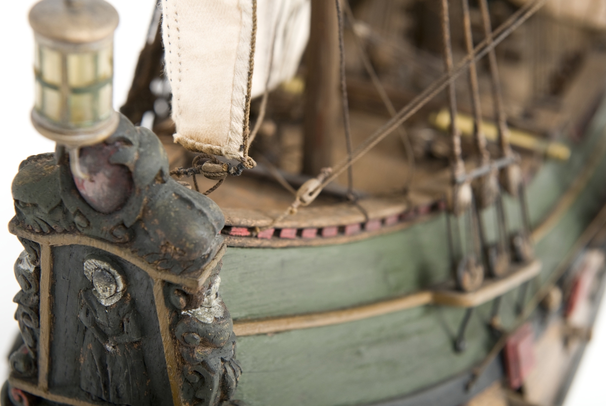 Flöjtskeppsmodell. Riggat med stående och löpande gods, segel av bomull. Bogspröt m. 2 blindor. Fock- o stormast med märs- och undersegel. Latinsegel på mesanmasten. Galjon m. lejon. 2 bogankare, båt på skrå midskeppsöver storluckan. På halvdäck 2 metallkanoner, 4 bogkanoner, samt 4 kanoner på låringen. 1 campagnelykta. Mörkbetsat skrov med 2 svarta berghult, svart bottenfärg. Akterspegel rikt ornerad med 6 fönster. Föremålets form: Helmodell
