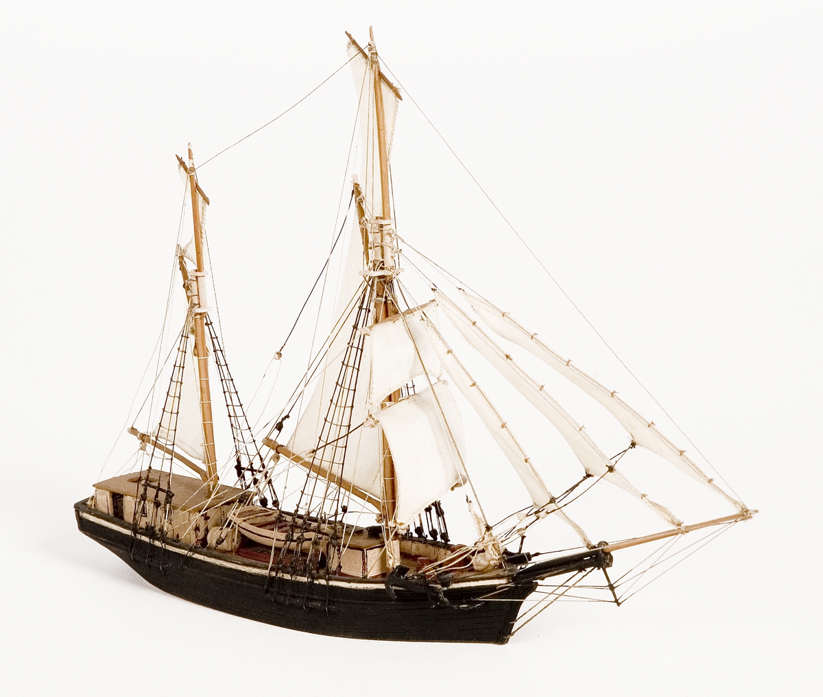Modell av galeas i block med segel av bomull. Kabyss vitmålad, storbåt midskepps. Kajuta med brunt tak. Svartmålat skrov.Föremålets form: Vattenlinjemodell