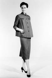 Modell i vid jacka, pennkjol och pumps.