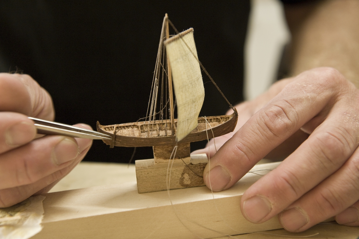 Modellbyggare Stefan Brun i arbete med en modell i skala 1:200 till utställningen "Shipping & Shopping".