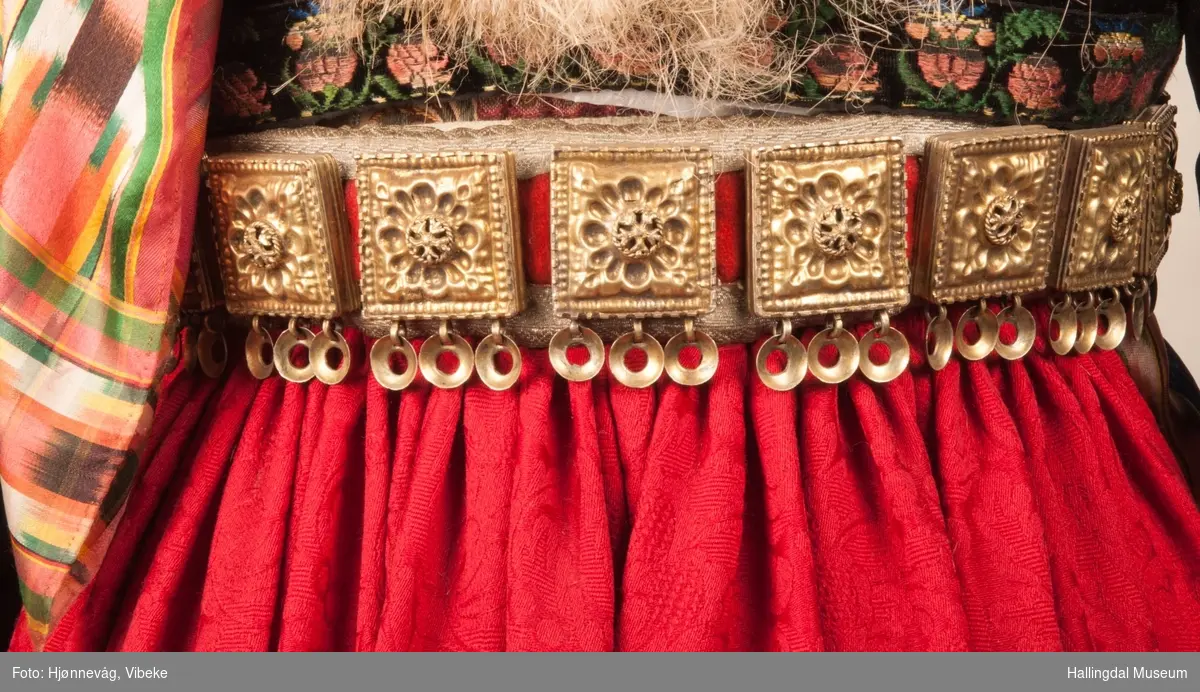Drakten står utstilt i den faste bunadutstillingen på Hallingdal Museum, Nesbyen.  Den ble satt opp på grunnlag av et bilde fra Norsk Folkemuseum, tatt ang. av Axel Lindahl.  Tidfestet til 1877-78.  Høyde på overdel ble bestemt etter lengden på trøya.  Utelatelsen av det store bryststykket og andre forandringer ble diskutert med Ågot Noss og godkjent.  Ny dokke ble bygd opp med utgangspunkt i stakkens mål.
HFN 03387-stakk med liv.  Stakk og liv ble skilt 5.1.1999, rød ulltråd med tråklesting festet delene sammen, fjernet.  Stakk festet til liv i ny høyde med store attersting med rødt bomullsgarn.  Det ble sydd understakk i ubleket lerret med vattering av dacronvatt, for å få riktig profil.
HFN 03386 Forkle er noe for kort.
HFN ? Skjortering, sydd fast i skjorta.
HFN 00677 sølje, sydd fast i skjorta.
HFN 00533 sølje sydd fast i skjorta.
HFN ? Perleklut, sydd fast i skjorta.
HFN 00560 Angus Dei, påsatt ny silkesnor.
HFN 06695 Silketørkle, blått, festet i forklesnora
HFN 03499 Silketørkle festet i forklesnora
HFN 06694 Silketørkle, rødt rundt halsen
HFN 03603 Brudelue
HFN 03137 Stølebelte, påsatt bendelbånd, disse ligger over skuldrene for å holde beltet oppe.
HFN 03318 Linskjorte.  Vasket: desember 2000
HFN 01815 trøye i svart speilfløyel.
