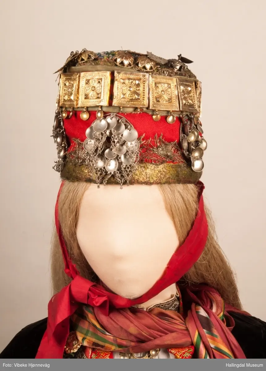 Drakten står utstilt i den faste bunadutstillingen på Hallingdal Museum, Nesbyen.  Den ble satt opp på grunnlag av et bilde fra Norsk Folkemuseum, tatt ang. av Axel Lindahl.  Tidfestet til 1877-78.  Høyde på overdel ble bestemt etter lengden på trøya.  Utelatelsen av det store bryststykket og andre forandringer ble diskutert med Ågot Noss og godkjent.  Ny dokke ble bygd opp med utgangspunkt i stakkens mål.
HFN 03387-stakk med liv.  Stakk og liv ble skilt 5.1.1999, rød ulltråd med tråklesting festet delene sammen, fjernet.  Stakk festet til liv i ny høyde med store attersting med rødt bomullsgarn.  Det ble sydd understakk i ubleket lerret med vattering av dacronvatt, for å få riktig profil.
HFN 03386 Forkle er noe for kort.
HFN ? Skjortering, sydd fast i skjorta.
HFN 00677 sølje, sydd fast i skjorta.
HFN 00533 sølje sydd fast i skjorta.
HFN ? Perleklut, sydd fast i skjorta.
HFN 00560 Angus Dei, påsatt ny silkesnor.
HFN 06695 Silketørkle, blått, festet i forklesnora
HFN 03499 Silketørkle festet i forklesnora
HFN 06694 Silketørkle, rødt rundt halsen
HFN 03603 Brudelue
HFN 03137 Stølebelte, påsatt bendelbånd, disse ligger over skuldrene for å holde beltet oppe.
HFN 03318 Linskjorte.  Vasket: desember 2000
HFN 01815 trøye i svart speilfløyel.