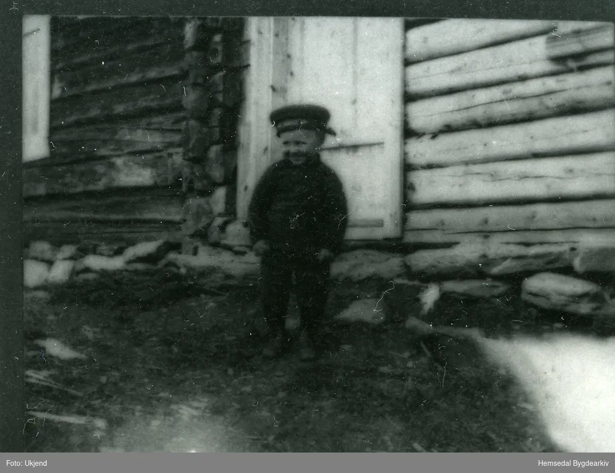 Sundag på Ålruststølen ein gong i 1924. Gardsguten Endre Aalrust, 2 år gamal, i finstas - bild som ei sol og med marinelua på hovudet.