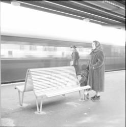 Västra tunnelbanan, tunnelbanebänk med kvinna, barn och man.