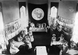 Sykepleiere holder tombola i banksalen i Harstad Sparebank. 