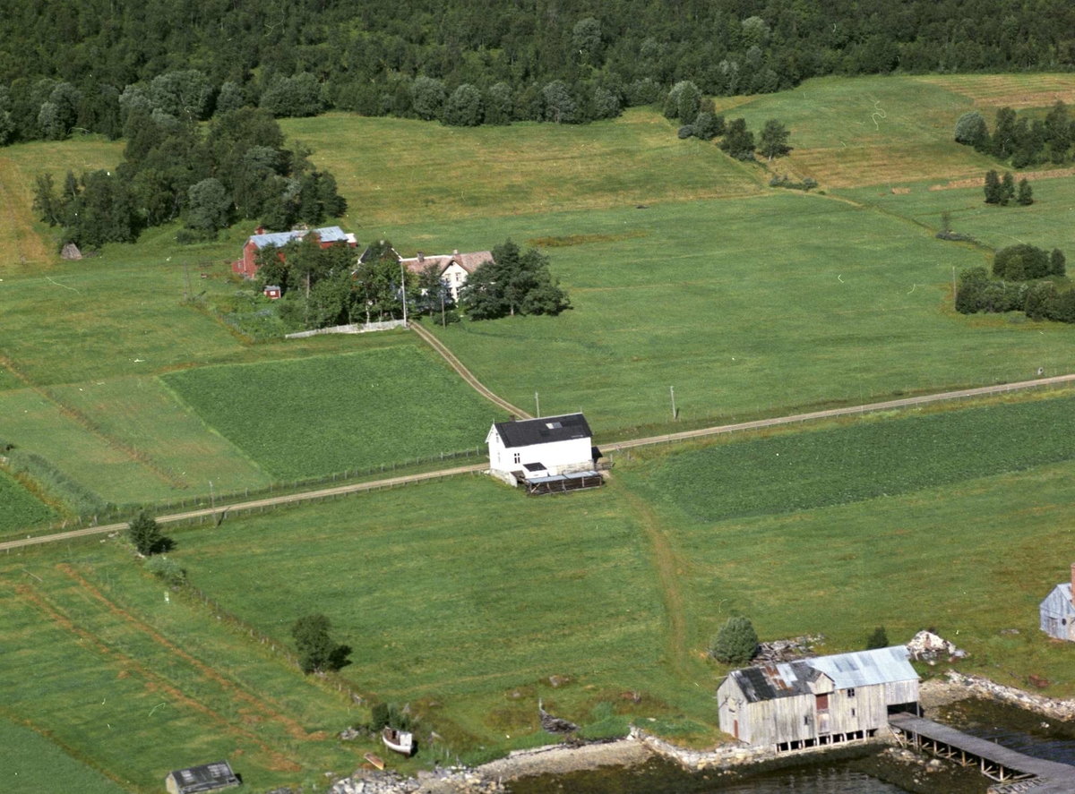 Flyfoto av Skjærstad. Brygge i forgrunnen, butikkene i midten og gårdstunet i bakgrunnen. I billedkanten helt til høyre ligger den gamle sildoljefabrikken.