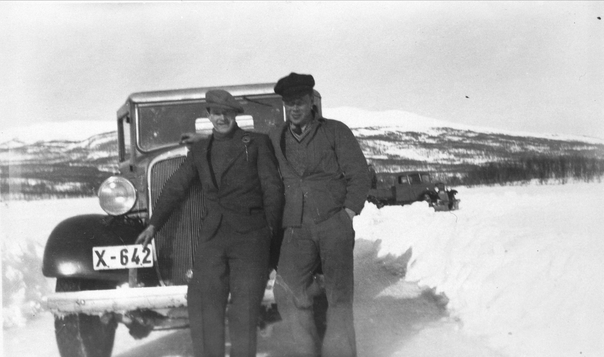 Chevrolet lastebil i vinterlandskap, med to menn poserende foran.