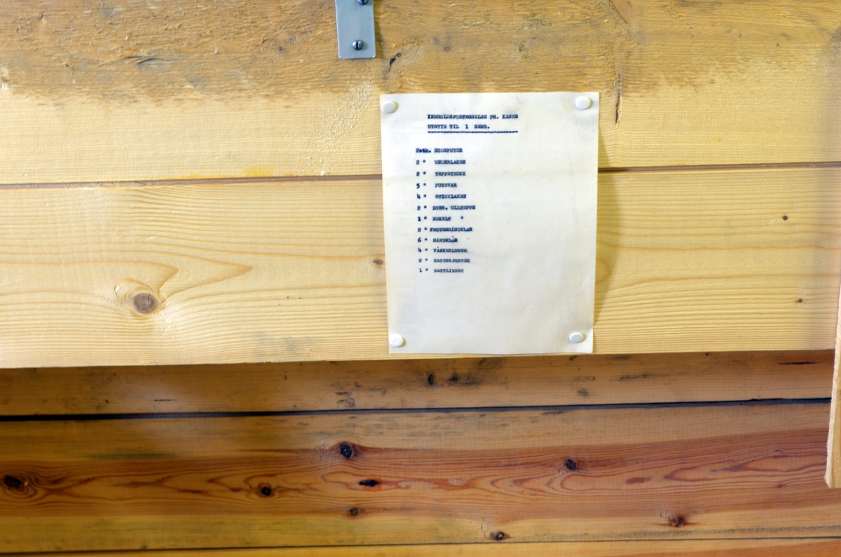 Kiste med lokk og lås. 

Trekiste laget av gorve plankebord. 
Kisten er umalt, foruten logoen til NKS. 
Inni kistelokket er det stiftet fast en utstyrsliste over hva kisten skal inneholde.