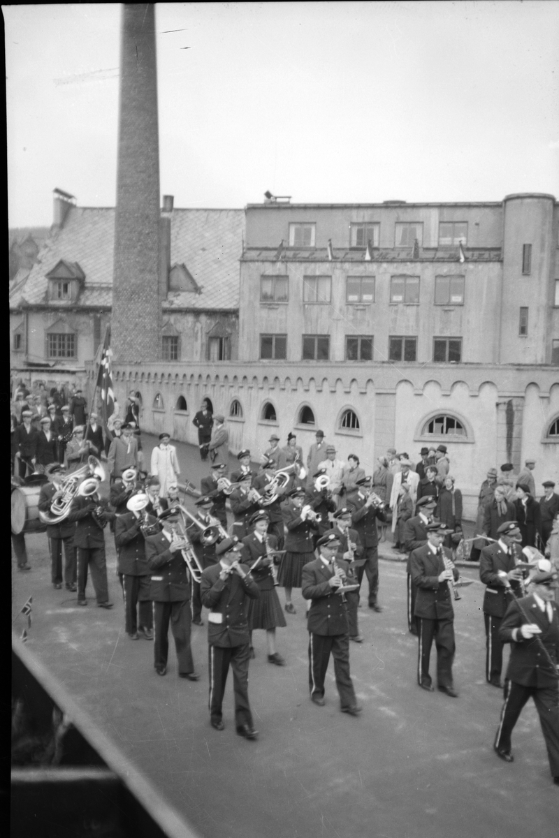 Harstad Janitsjar marsjerer ned Hvedings gate på 17. mai, 1959. I bakgrunnen det gamle meieriet.