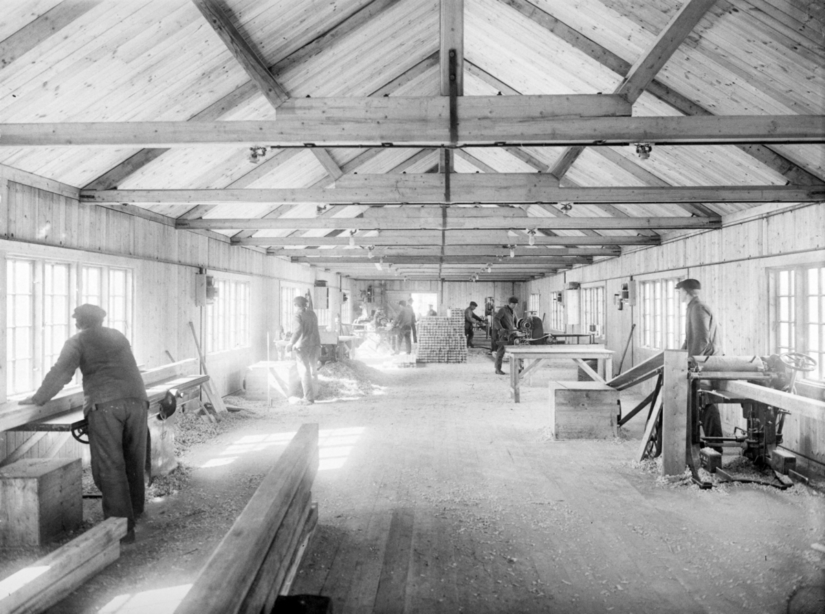 Interiørbilde fra brakke. Menn i arbeid ved snekkermaskinene. Fra originalprotokollen: " Verksted Spørch, inne, Haslund -Barakke comp."