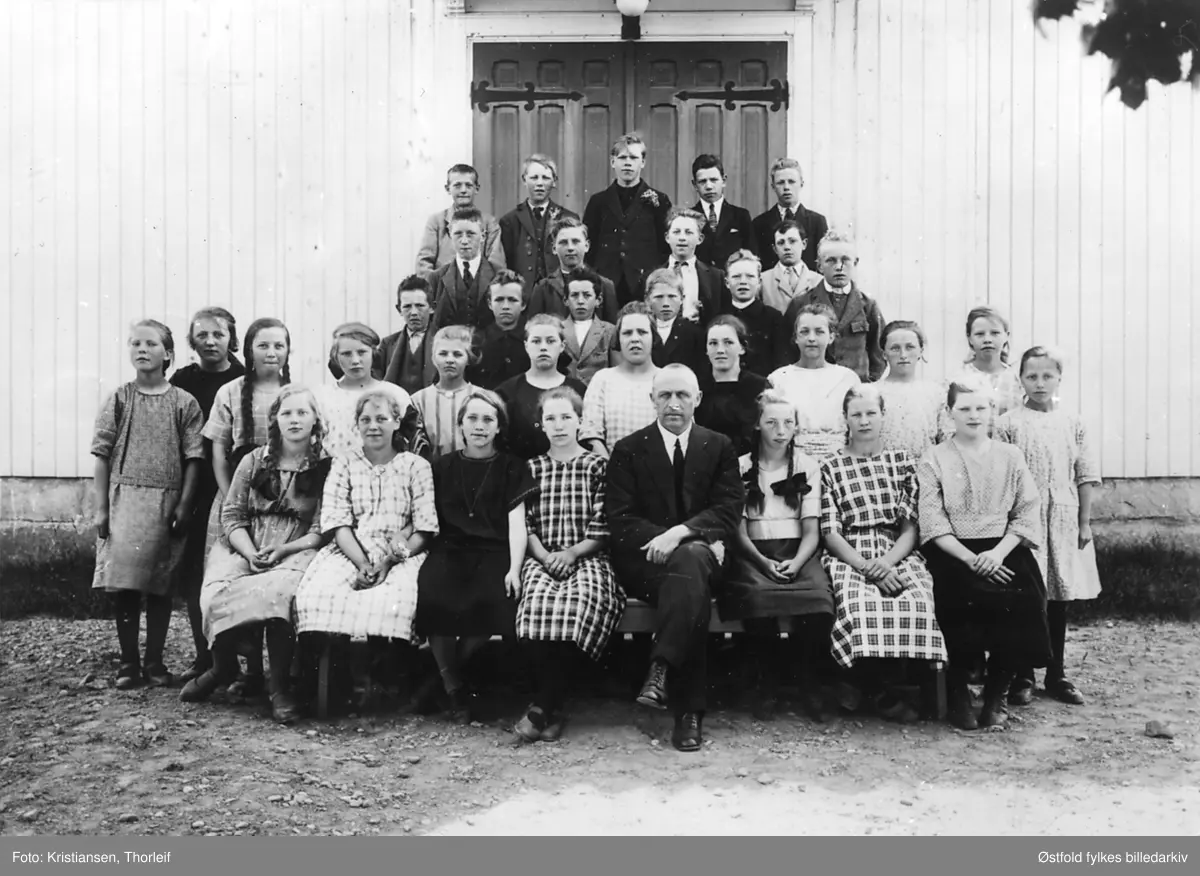 Konfirmanter i Varteig i 1923 med presten Henrik Greve Hille utenfor kirken.