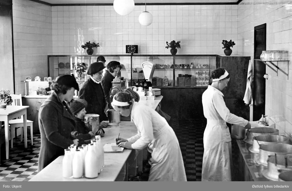 Butikkinteriør fra Fredrikstad Aktiemeieri i 1938. Melkebutikk med kafe, tre kvinnelige ekspeditører.