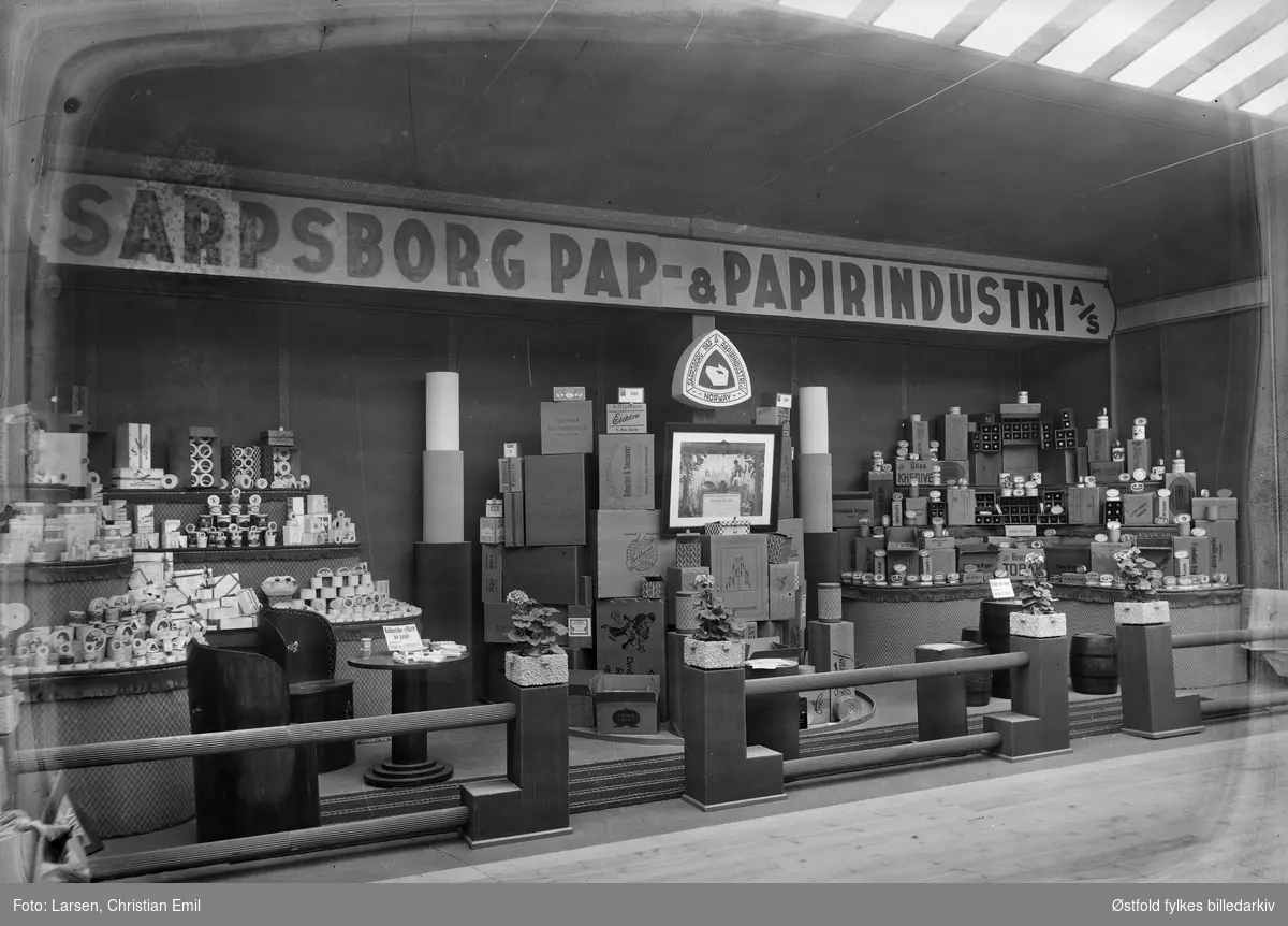 Østfoldutstillingen i Sarpsborg 1930. Utstillingsinteriør: Sarpsborg Pap & Papirindustri A/S. 
Østfold fylkesutstilling i samarbeid med Sarpsborg kommune og Østfold landbruksselskap (100 år) og de andre Østfoldbyene. 
I alt ti avdelinger for skogbruk, landbruk, industri, husflid, osv. Også kulturhistorisk utstilling på Borgarsyssel Museum.