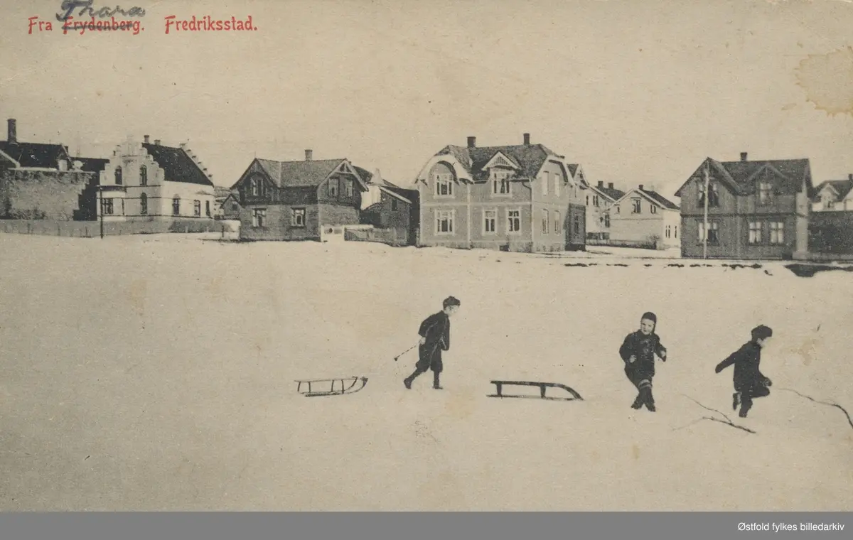 Trara i Fredrikstad, vintermotiv.
 I forgrunnen  tre barn som leker i snøen med kjelker. Poststempel fra 1913. Frydenberg er overstrøket og Trara er skrevet over på postkortets tittel.

Bildet er tatt fra Steffensjordet mot Øyvind Sørensens gate på Trara. Jernbanen går rett foran husene. Helt til venstre sees baksiden av kinolokalet Røde Mølle. Det neste huset med takkete gavler er Villa Elisabeth i Øyvind Sørensens gate 2.