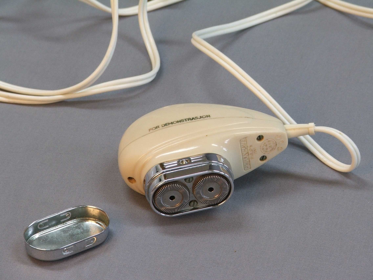 Oval, rund form "som ligg godt i handa". Blank ende med blankt lok. Tar du av loket er det to runde former inni. Ledning. Støpsel. På undersida av støpsel er det ulike innstillingar på "volts" ein kan skyve fram og attende.