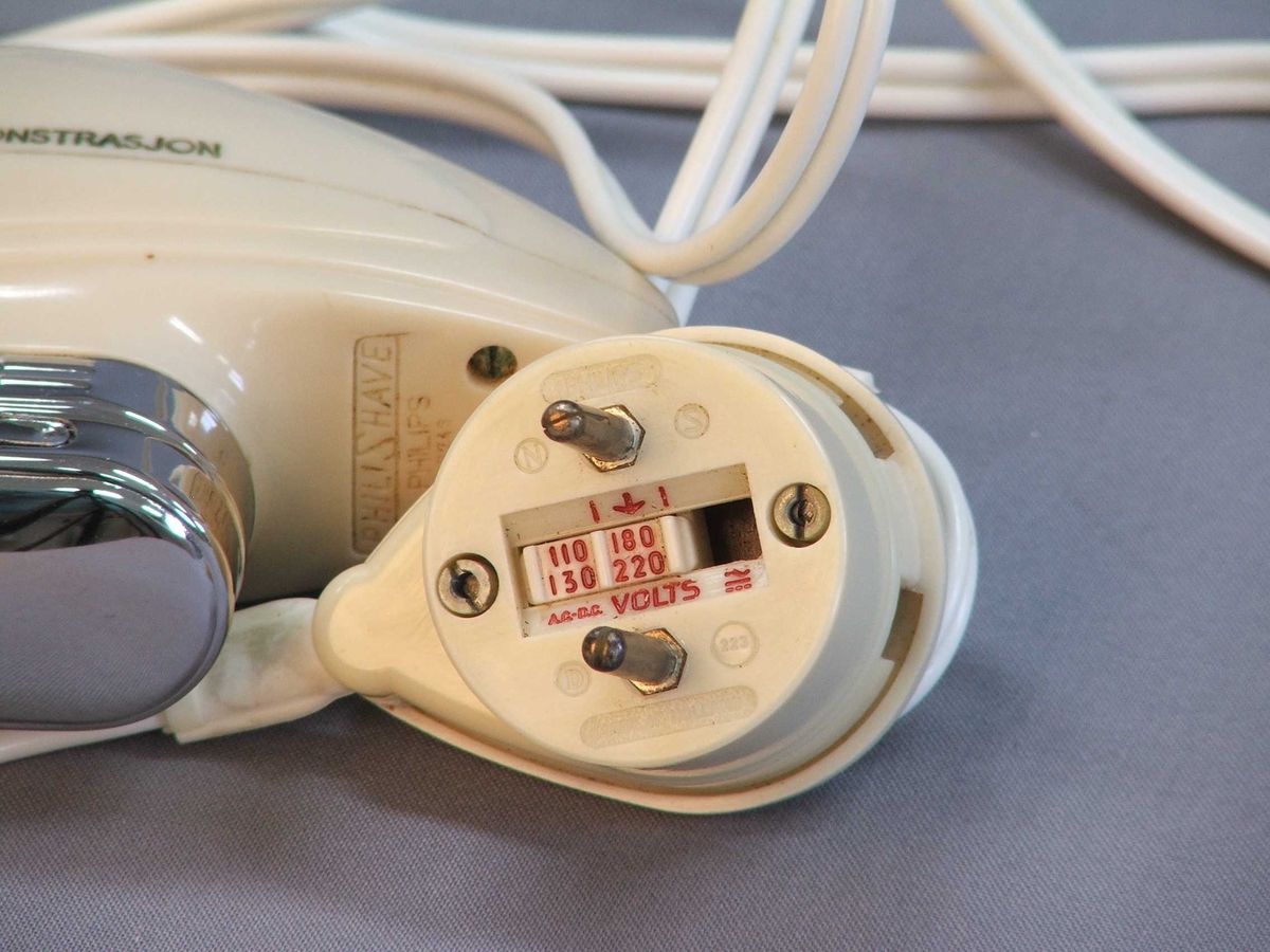 Oval, rund form "som ligg godt i handa". Blank ende med blankt lok. Tar du av loket er det to runde former inni. Ledning. Støpsel. På undersida av støpsel er det ulike innstillingar på "volts" ein kan skyve fram og attende.