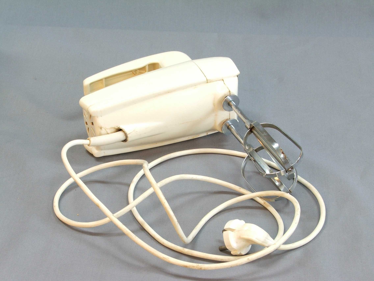 Miksmastar i fem delar: Stativ, bolle, maskin med leidning, to vispar. Stativet er av stål, her kan bollen stå oppå og maskinen stå ned i ei råme med vispane ned i bollen. Bollen er i rustfritt stål. Maskinen er tung, handtak øvst, knapp med fire trinn også øvst. Uttak til vispar under. Vispar samansett av to ovalar med stålband.