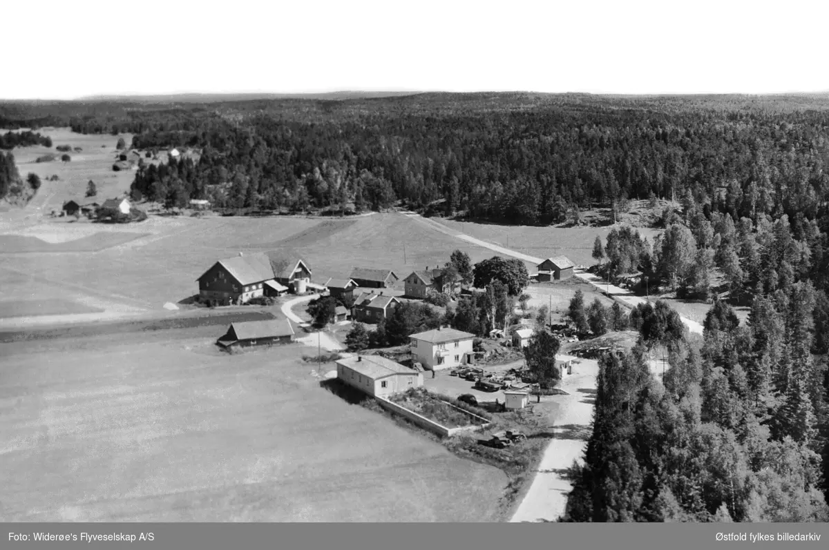 Flyfoto fra Rødsund i  Våler, Østfold.
I forgrunnen bilverksted, bolig, kiosk og Shell bensinstassjon, eid av Svein Røstad (1997). Bensinstasjonen ble bygd ca. 1950-55, nedlagt på slutten av 1950-tallet pga omlegging av riksvei 120. Kiosken revet for få år siden. Gården tilhørte  Alf Hovland. 

Biler: Ford, Hudson, Opel. Flere opplysn. se dok.reg.