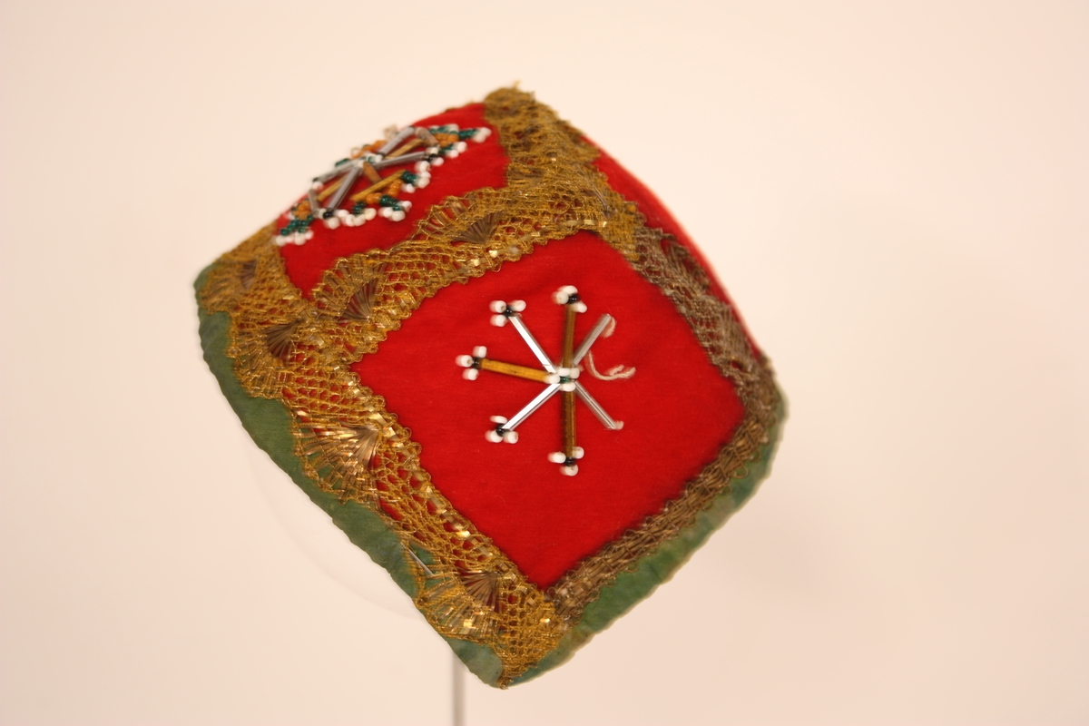 Raudt klede . Gullband. Perlebroderi. Kanta med grøne silkeband. 