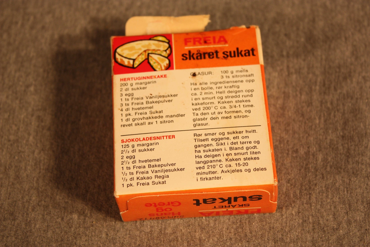 Originalpakning med sukat, opna og brukt av. På framsida bilete av brød med sukat og rosiner, på baksida oppskrifter.