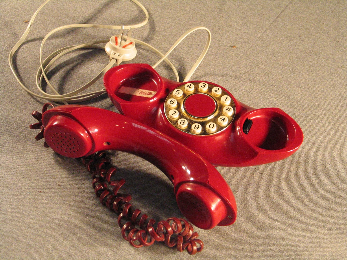 Båtforma haldar med tastatur. Står på ein liten oval stett. Rund gullforgyllt talskive med firkant- og stjernetast.Når røyret er lagt på har apparatet ein oval profil med opning i midten. Ledning med stikkontakt.
Sjå referansar/andre oppl.