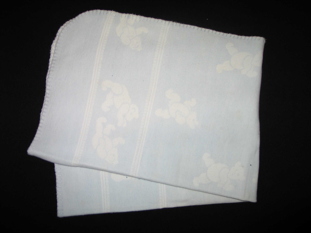 Teppet er kvitt på den eine og blått på den andre sida. På den blå sida er kvite bamsar, på den kvite sida er blå bamsar.