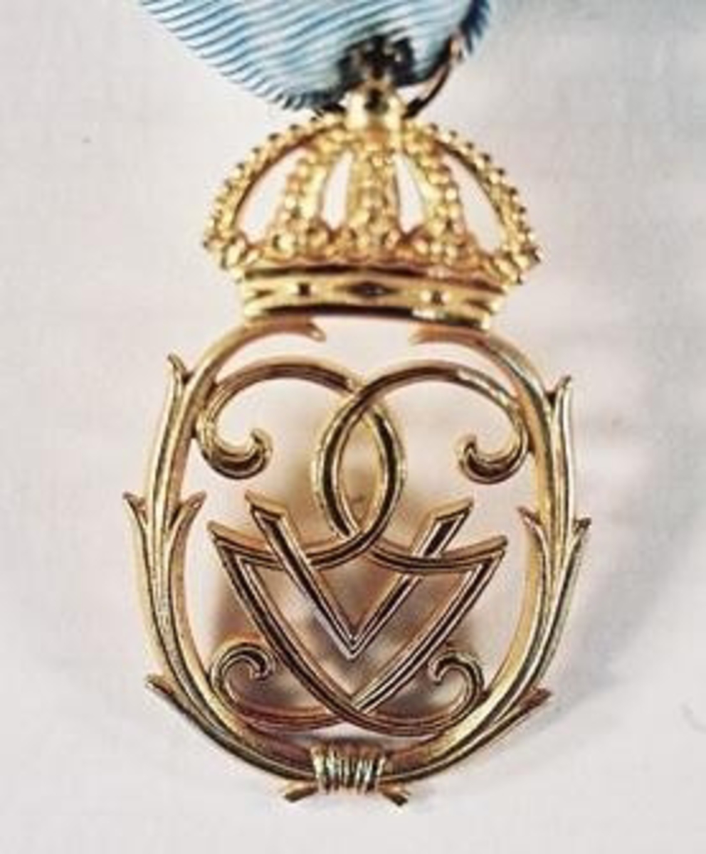 Medaljen vilken tillhört Erik T:sson Uggla. Konung Gustav Vs jubileumstecken II utdelad 16/6 1948 med anledning av konungens 90-årsdag, ritat av Erik Fleming och tillverkat hos Borgila ateliés i Stockholm. 887 utdelades. 

Erik T:sson Uggla föddes 1906 i Lund där han avlade jur.kand . examen 1936 . Han tjänstgjorde vid Västerbygdens vattendomstol 1940-1971. Han var härold i kungl. Majt. s orden 1961-1974 . Uggla var en intresserad personhistoriker och redigerade flera årgångar av Ordenskalendern. Han varpresident i Vänersborgs Rotaryklubb 1950-1951. Han var gift med Birgit Kjerrulf, se VM 21 435. Överlämnat av sonen till ägaren.

I samlingen ingår:
21 495:1   Lilla Serafimertecknet. Serafimerordens Riddartecken. Fastsydd på en nål. Mått: 5,8x3,7 cm.
21 495:2   Nordstjärneordens Riddartecken. Fastsydd på en nål. Mått: 5,9x3,9 cm.
21 495:3   Vasaordens Riddartecken. Fastsydd på en nål. Mått: 6,1x3,9 cm.
21 495:4   Konung Gustaf V:s jubileumstecken 1948. Fastsydd på en nål. Mått: 5x3cm.
21 495:5   Konung Gustaf VI Adolfs jubileumsmedalj 1967. Fastsydd på nål. Mått: 4,5x3,1 cm.
21 495:6   Konung Carl XVI Gustavs medalj. 1977. Fastsydd på en nål. Mått: 4,5x3 cm.
21 495:7   Sankt Olavsordens Riddarkors. Fastsydd på nål. Mått: 6,1x4,1 cm.

Samlingen kom till museet via testamente. Erik T:sson Uggla hade tidigare köpt ut alla ordnar och tecken för att kunna testamentera dessa till Vänersborgs museum.

I länsmuseets arkiv finns en personmapp med inbjudningar till hovet ställda till paret Uggla.