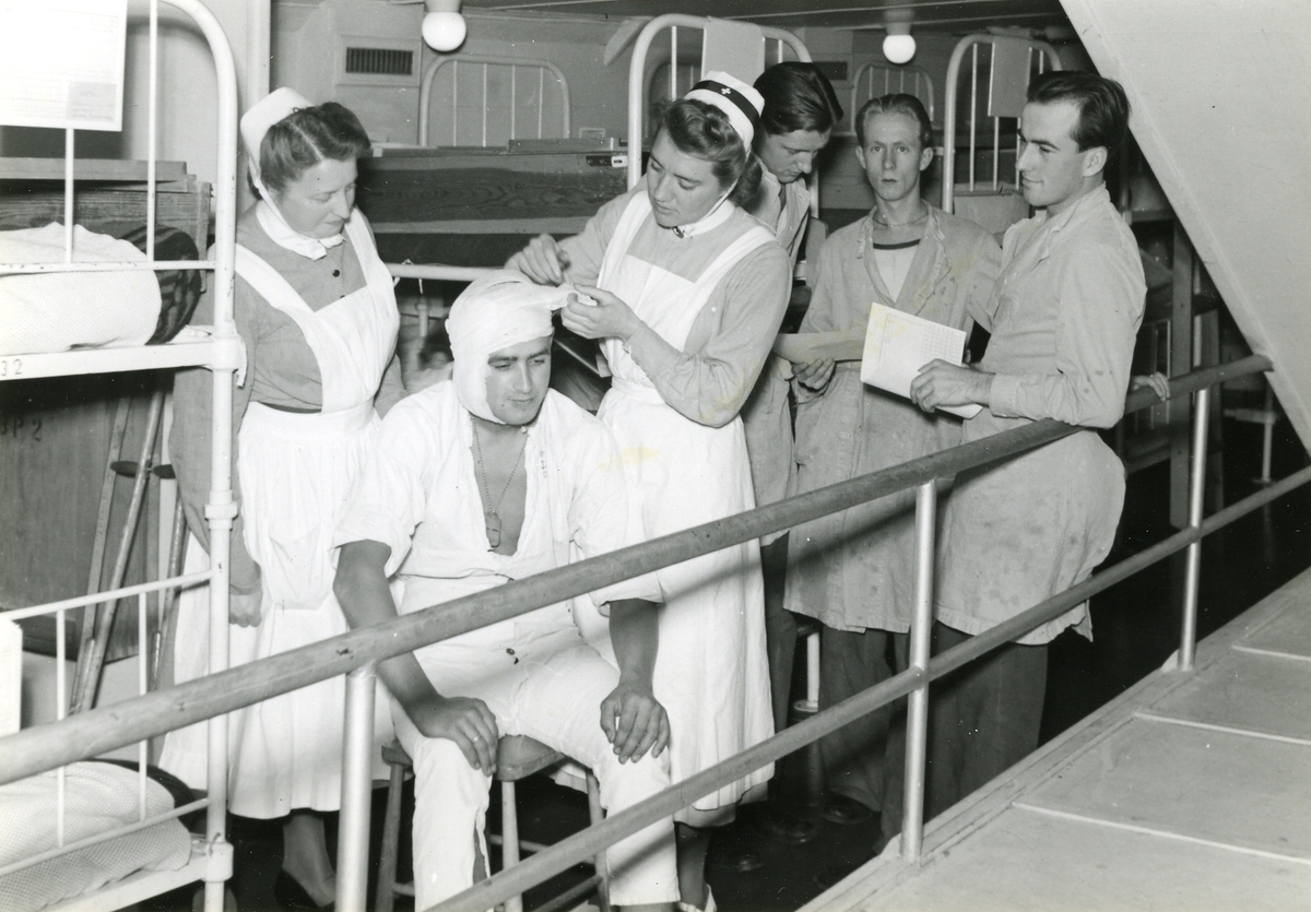 Sjuksyster lägger bandage om huvudet på en patient, troligen ombord på lasarettssfartyget Prins Carl.