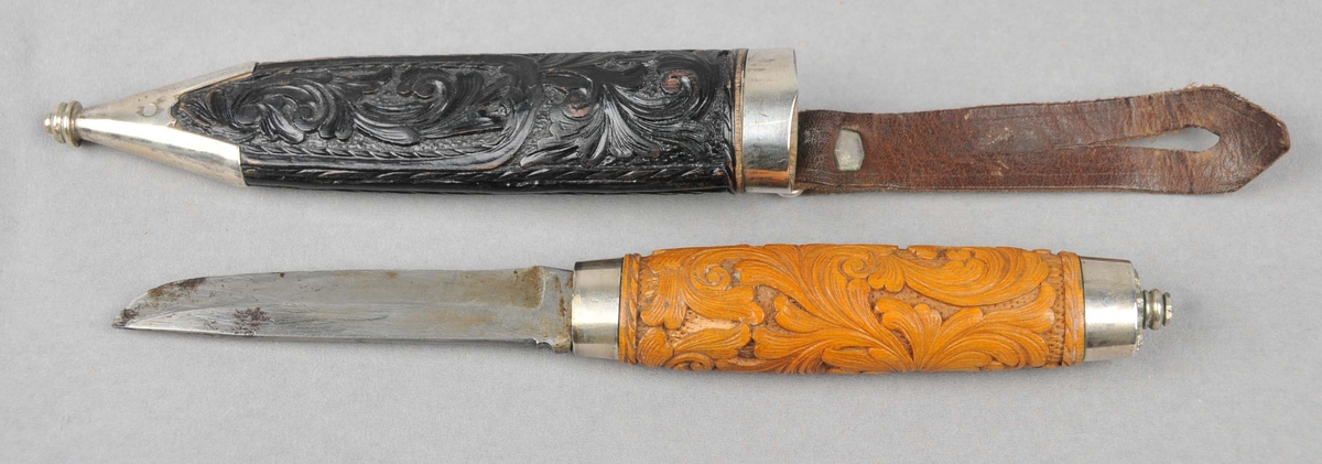 Kniv med utskore treskaft. Rosemønster. Holkar. Bladet er ustempla. Slira er utskoren og har sylvholkar.