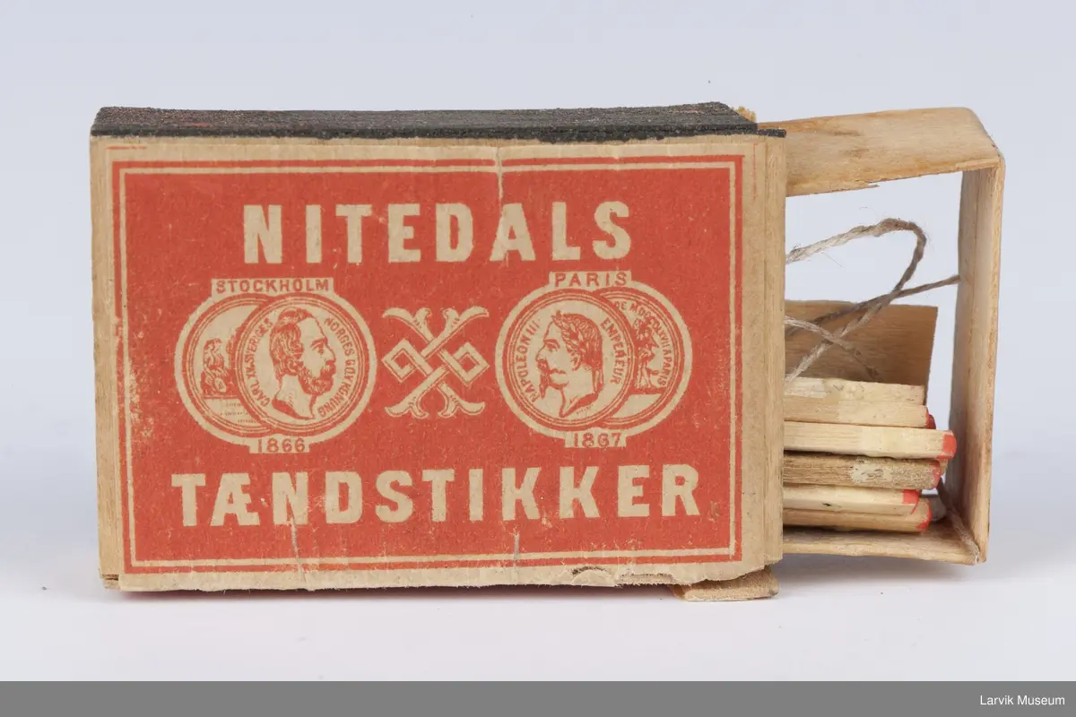 På lokket tekst og 2 mynter på hver side av et ornament med 