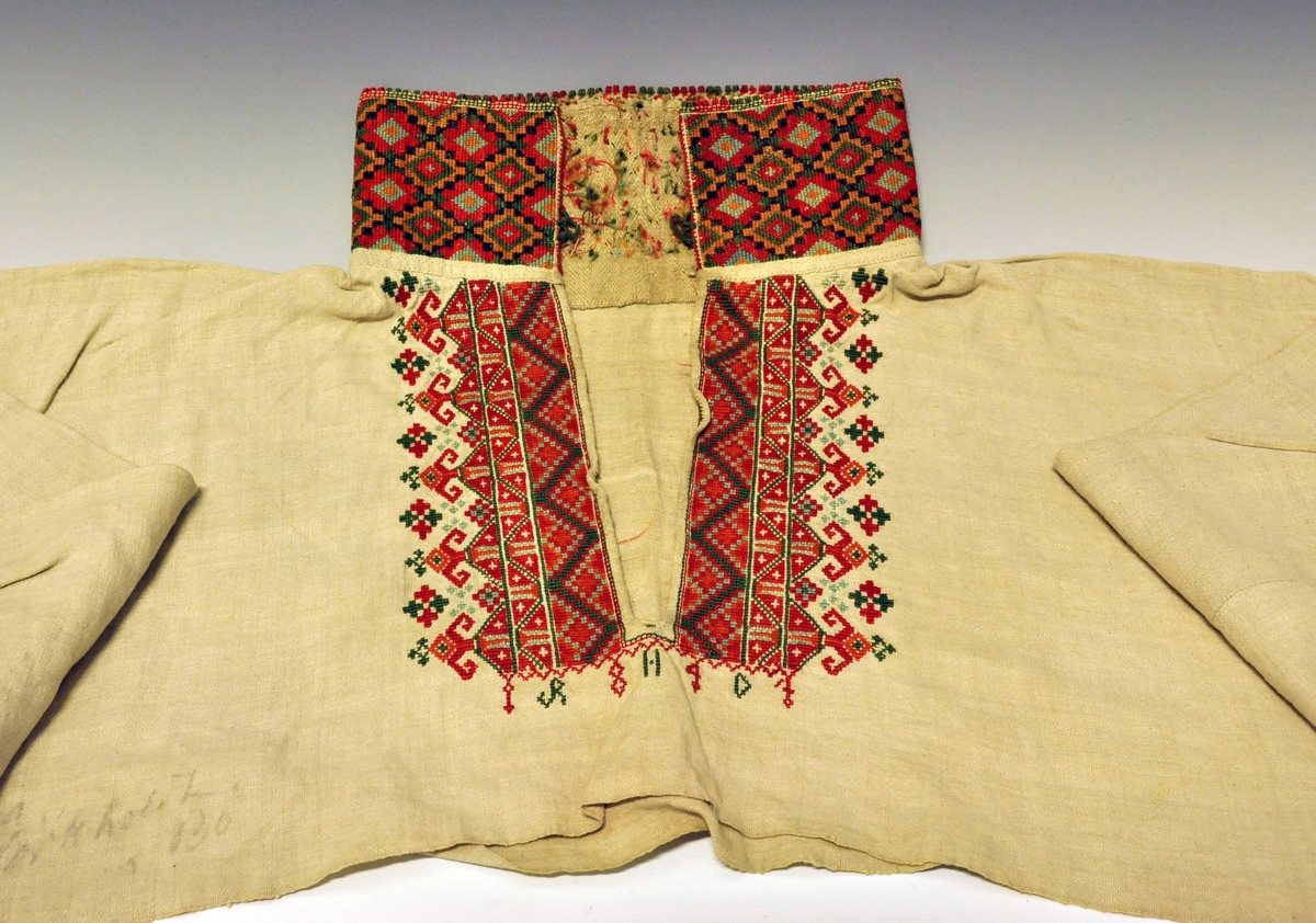 Skjorte. Øst-Telemarks kvinneskjorte med korsstingsbroderi på halskvarde, ermekvarder (linninger) og på bryststykket. Initialene R. H. D. og årstallet 1847 er brodert på skjorta nedenfor halsåpningen, splitten, på skjorta. Fra protokoll.