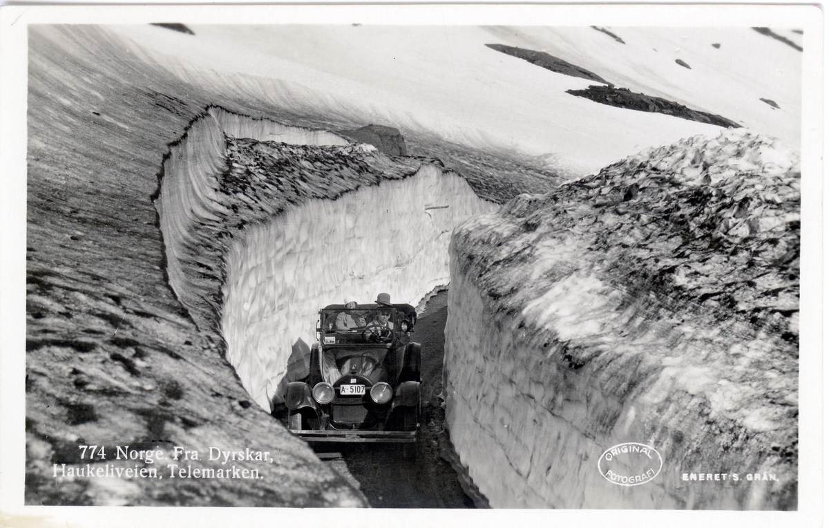 Postkortmtiv av drosje fra Dyrskar på Haukeliveien.

Påtrykk på postkort:

774 Norge fra Dyrskar, Haukeliveien, Telemarken

A-5107 er en Buick 1919-23 modell, står som drosje på dette merke. 

Eier: Arthur Hansen, Sofies gt. 9, Oslo. I 1922- og 30-utgavene med annen eier og bilmerke på dette nummer. A-5000-serien var reservert drosjer i Oslo.

(Kilde: Bilboken for Norge 1925, kommentar fra Digitaltmuseum.no bruker)