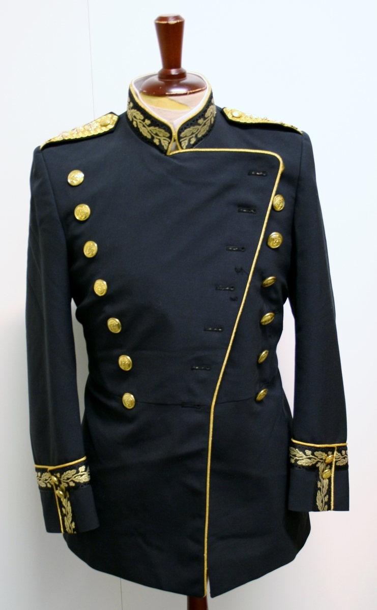 Foret, sort jakke med gullbrodert eikeløv med nøtter på krave og på ermer. 14 gullforgylte knapper i front, to på hvert erme og seks ved splitten bak. Gullkant langs hele fronten, på kraven på ermene og ved splitten. Epåletter i flettet gull med fire stjerner og eikeløv (politidirektør). Hvit løssnipp festet med borrelås.

Langt, sort skjørt med gullrender i sidene og glidlås bak.

Sort politilue med luemerke i gull og rødt og eikeløvsbroderier i sort og gull. To forgylte knapper holder luesnoren på plass.

Sort stoffbelte med gullkant innvevd mønster (eikeblad og sikksakkbord) Rektangulær beltespenne i gullforgylt metall med riksvåpen. Beltets lengde kan reguleres med borrelås på innsiden, og er nå 90 cm langt medregnet spennen.

Det hører til hvite hansker, men disse mangler.