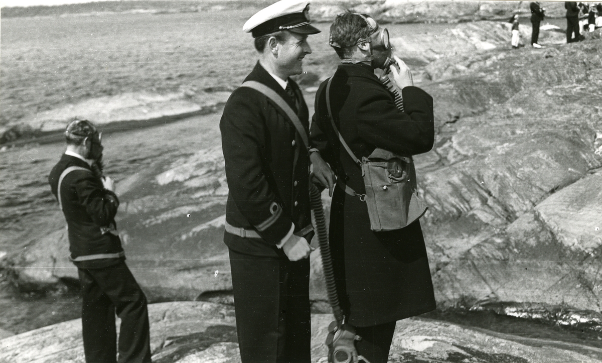 Officerare med gasmask under skyddsövning i land.
