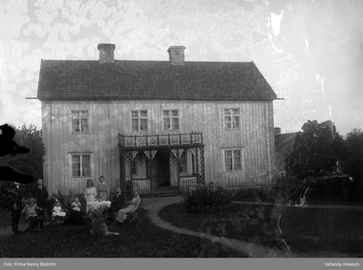 Familjefoto utanför oidentifierat hus.