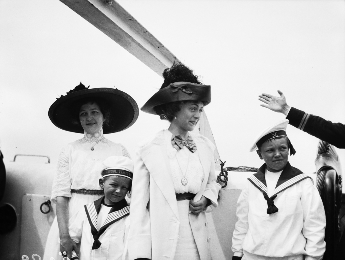 Två kvinnor med pojkar klädda i sjömanskostymer vid hembygdsfesten i Borgholm midsommardagen 1912.