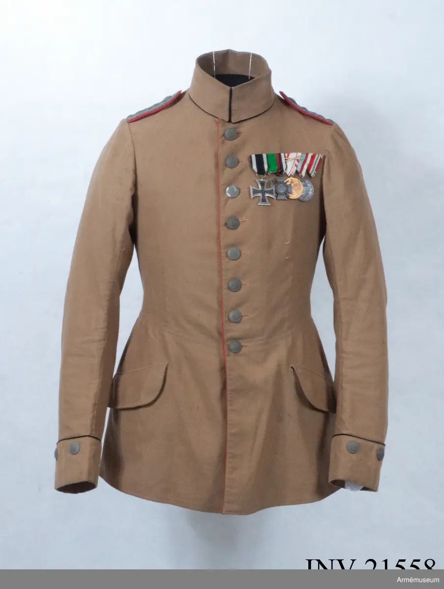 Grupp C I.
Ur uniform för kapten vid Fältartilleriregementet Grossherzorg Nr 14, Baden-Baden, Tyskland. Uniformen infördes för trupper på Balkan-fronten åren 1916-18. Buren av K Killander 1886-1951 under tjänstgöring i Tyska armén 1914-18.
Av brun kaki. Åtsittande. Enradig med 8 knappar. På båda backfickorna tvåuddigt lock, vardera med 3 knappar. På framsidan finns twå sneda fickor med lock. Axelklaffar, l:110 mm, b:45 mm. På axelklaffarna två stjärnor =kaptens grad flammande granat - artilleriets kännetecken. Foder saknas. Knappar grå matta, metall med ingraverad krona, d:20 mm. Krage dubbel nedviken med svart passpoll på kragens fram och nedre kant. Passpoaler, röda, längs rockens främre kant och på bakfickorna.  Ärmuppslag, rakskuren, 6 cm höga med 2 knappar och svart passpoal vid ärmuppslagets övre kant.