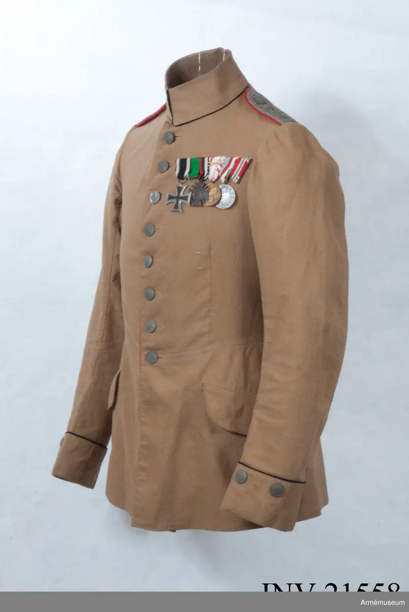 Grupp C I.
Ur uniform för kapten vid Fältartilleriregementet Grossherzorg Nr 14, Baden-Baden, Tyskland. Uniformen infördes för trupper på Balkan-fronten åren 1916-18. Buren av K Killander 1886-1951 under tjänstgöring i Tyska armén 1914-18.
Av brun kaki. Åtsittande. Enradig med 8 knappar. På båda backfickorna tvåuddigt lock, vardera med 3 knappar. På framsidan finns twå sneda fickor med lock. Axelklaffar, l:110 mm, b:45 mm. På axelklaffarna två stjärnor =kaptens grad flammande granat - artilleriets kännetecken. Foder saknas. Knappar grå matta, metall med ingraverad krona, d:20 mm. Krage dubbel nedviken med svart passpoll på kragens fram och nedre kant. Passpoaler, röda, längs rockens främre kant och på bakfickorna.  Ärmuppslag, rakskuren, 6 cm höga med 2 knappar och svart passpoal vid ärmuppslagets övre kant.