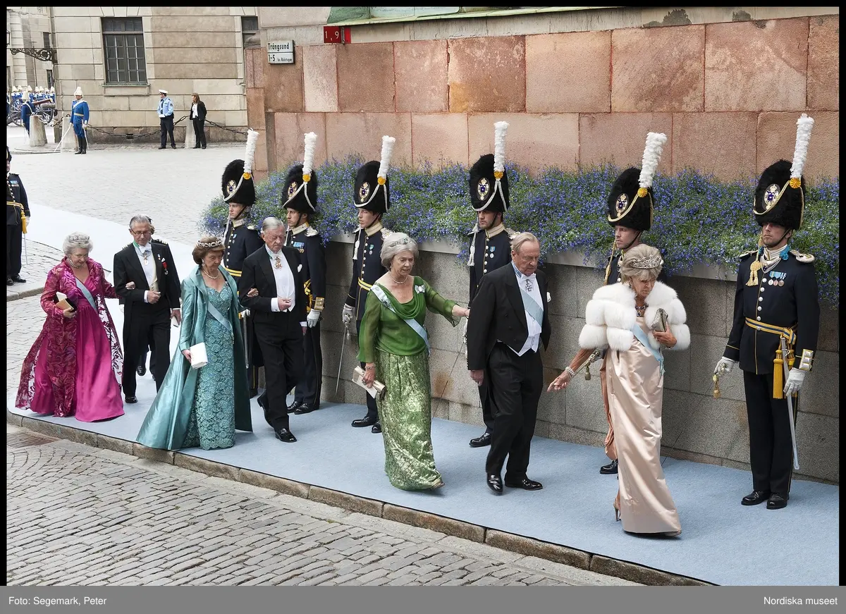 Kronprinsessbröllopet. Dokumentation av bröllopet mellan Kronprinsessan Victoria och herr Daniel Westling 19 juni 2010. Gästerna anländer till Storkyrkan. Prinsessan Birgitta längst fram i champagnefärgad sidenklänning med vit pälsjacka, drottning Sofias diadem, smycken, kuvertväska och ordenstecken. Prinsessan Birgittas make, Johan Georg av Sigmaringen i frack och ordenstecken. Prinsessan Margaretha i grön klänning med brokad och transparent blus, diadem med akvamariner, smycken, kuvertväska och ordenstecken. Prinsessan Désirée i turkos klänning med brokad och aftoncape i siden i samma nyans, juvelgarnityr med ametister och briljanter, vit kuvertväska och ordenstecken med maken Nicklas Silfverschiöld i frack. Prinsessan Christina i cyklamenröd klänning i blank sidensatin med brokadvävd aftonkappa, Karl Johan-diademet, smycken, kuvertväska och ordenstecken med maken Tord Magnuson i frack.