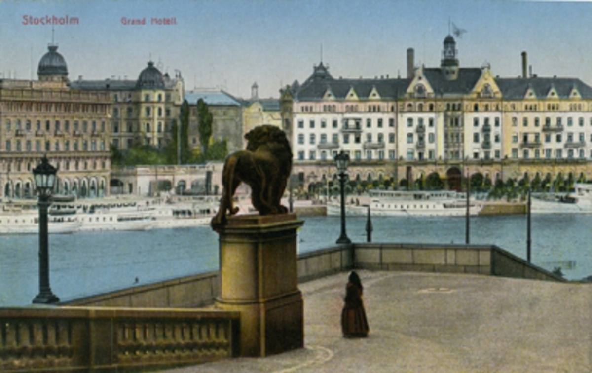 Stockholm. Vy från Lejonbacken över Södra Blasieholmshamnen med Grand Hotel i bakgrunden. Kolorerat vykort, färglitografi.