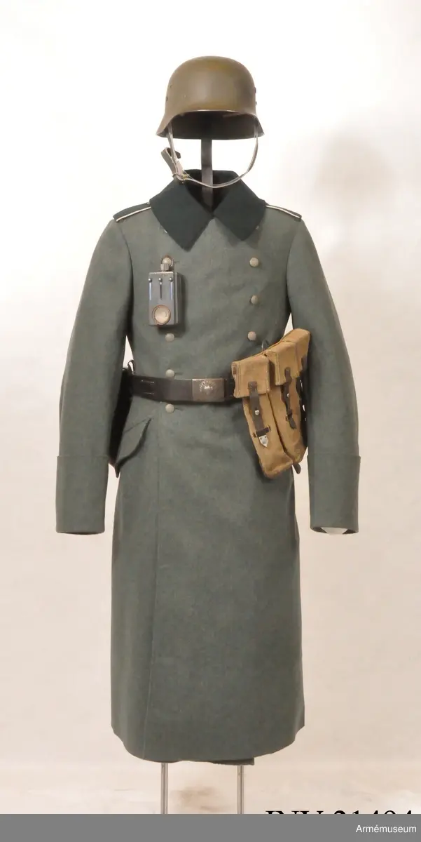 Överrock (1937) för menig vid infanteriet. Av fältgrått kläde. Tvåradig med 6 knappar i vardera rad. Baktill en inskärning som knäpps med 4 benknappar inuti, i livet en sleif som består  av två delar. Axelklaffar av mörk grönt kläde med vit passpoil omkring, b:45 mm. Foder av grått tyg. Knappar av grå metall. Ärmuppslag rakskurna, h:160 mm.