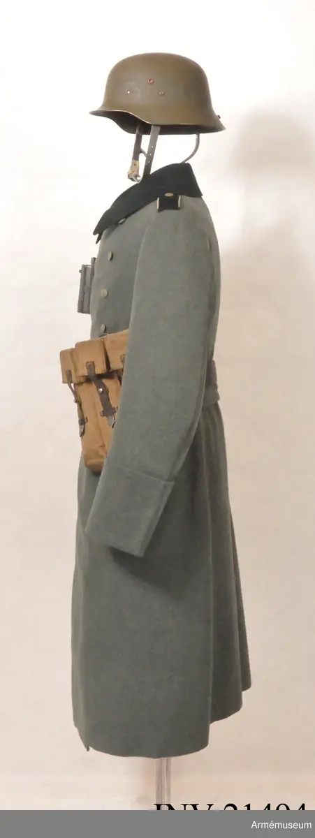 Överrock (1937) för menig vid infanteriet. Av fältgrått kläde. Tvåradig med 6 knappar i vardera rad. Baktill en inskärning som knäpps med 4 benknappar inuti, i livet en sleif som består  av två delar. Axelklaffar av mörk grönt kläde med vit passpoil omkring, b:45 mm. Foder av grått tyg. Knappar av grå metall. Ärmuppslag rakskurna, h:160 mm.