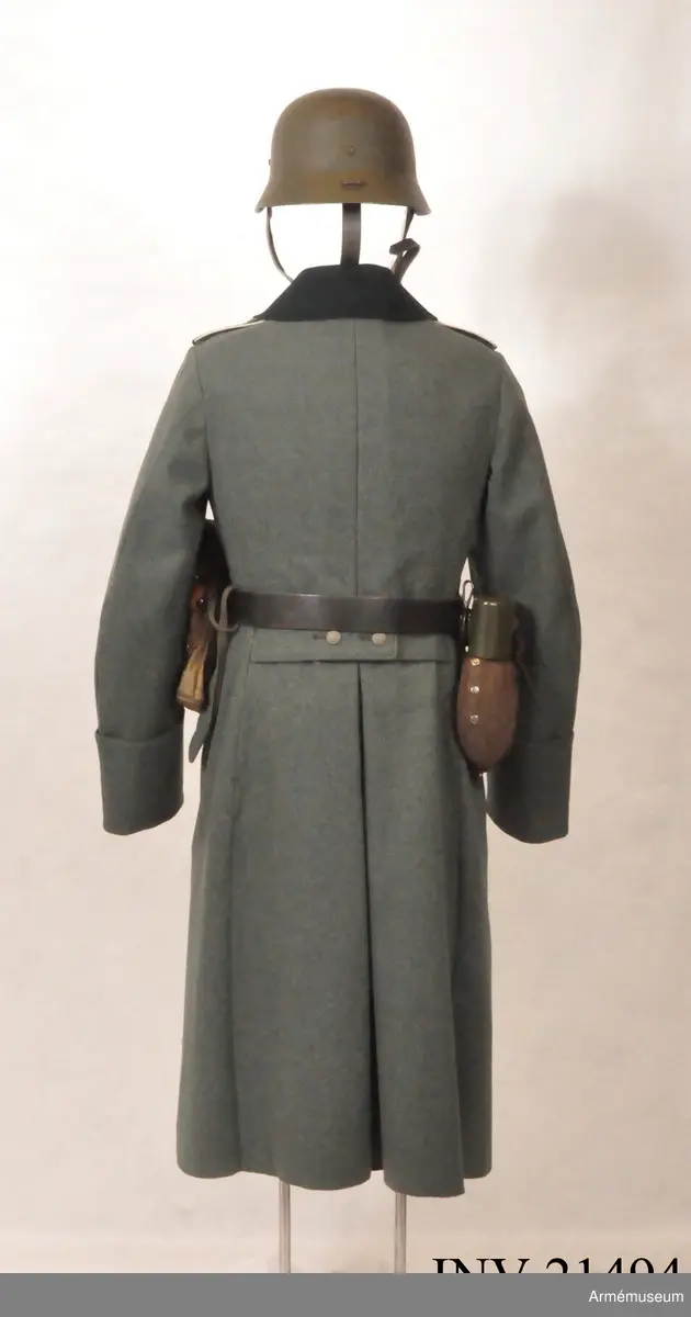 Överrock (1937) för menig vid infanteriet. Av fältgrått kläde. Tvåradig med 6 knappar i vardera rad. Baktill en inskärning som knäpps med 4 benknappar inuti, i livet en sleif som består  av två delar. Axelklaffar av mörk grönt kläde med vit passpoil omkring, b:45 mm. Foder av grått tyg. Knappar av grå metall. Ärmuppslag rakskurna, h:160 mm.