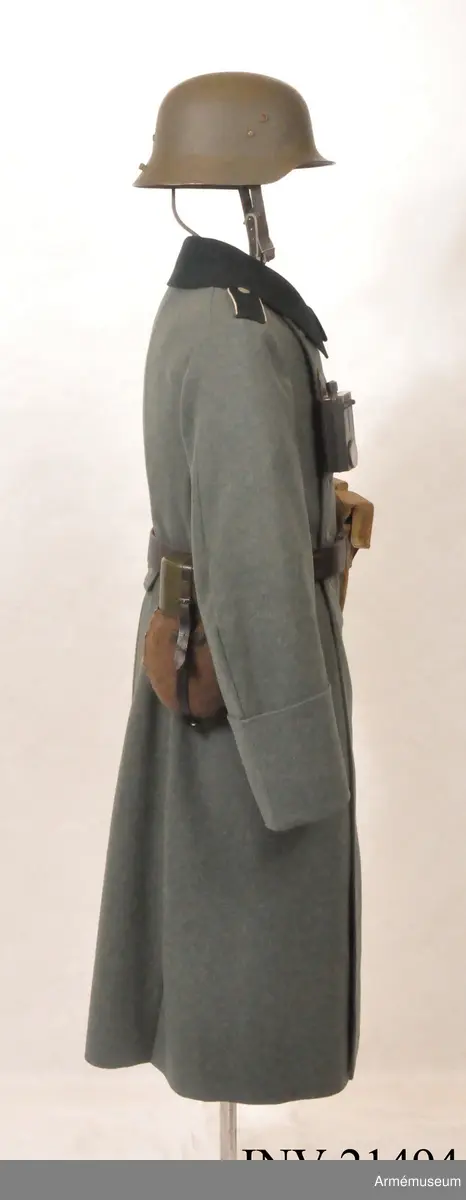 Överrock (1937) för menig vid infanteriet. Av fältgrått kläde. Tvåradig med 6 knappar i vardera rad. Baktill en inskärning som knäpps med 4 benknappar inuti, i livet en sleif som består  av två delar. Axelklaffar av mörk grönt kläde med vit passpoil omkring, b:45 mm. Foder av grått tyg. Knappar av grå metall. Ärmuppslag rakskurna, h:160 mm.
