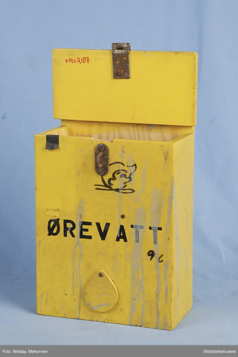 Kasse av tre, gulmalt; merket Ørevatt. Hull til å dra ut ørevatt av, i nederste del av kassen