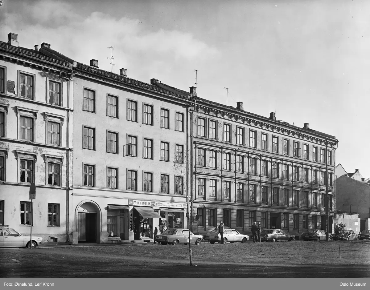 gateløp, bygårder, kolonialforretning, frukt- og tobakksforretning, biler, mennesker
